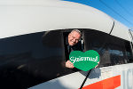 Bildbeschreibung: Zugtaufe des ICE 4 „Steiermark“ am Grazer Hauptbahnhof. Ein Mann lächelt aus einem Zugfenster, hält ein grünes Herz mit dem Aufdruck „Steiermark“.