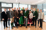 Gruppe von Menschen in traditioneller steirischer Tracht steht lächelnd zusammen.