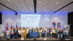 Gruppenfoto von Teilnehmenden eines Netzwerftreffens der Steiermark mit Landes- und EU-Flaggen im Hintergrund.