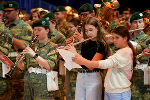 Bildbeschreibung: Blaskapelle in Uniform musiziert gemeinsam mit Schülern.