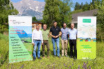 Mehrere Personen stehen vor einer Werbetafel mit dem Logo 'Naturpark Steiermark'. Thema: Landschaft und Biodiversität.