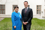 Bildbeschreibung: Eine Frau und ein Mann stehen in einem Innenhof mit Wiese.