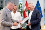 Drei Männer bei der Überreichung der Urkunde