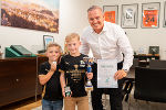 Eine erwachsene Person steht mit zwei Kindern in einem Büro.