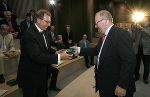 v.l.: Wirtschaftslandesrat Dr. Christian Buchmann überreicht Niels Jacobsen, CEO der Firma Oticon, als Gastgeschenk die multzimediale Standortpräsentation der Steiermark 